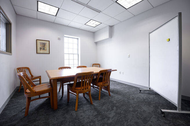 interior of a study room showing a table, 7 chairs, and a whiteboard