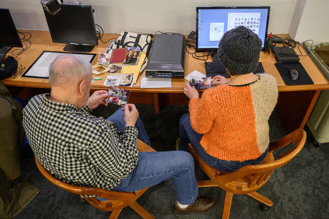 Two patrons looking at photographs while at a scanning station