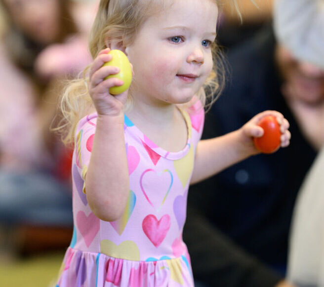 Young child holding egg shakers