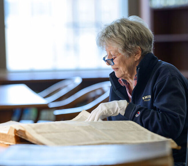 Researcher in archives looking at old newspapers